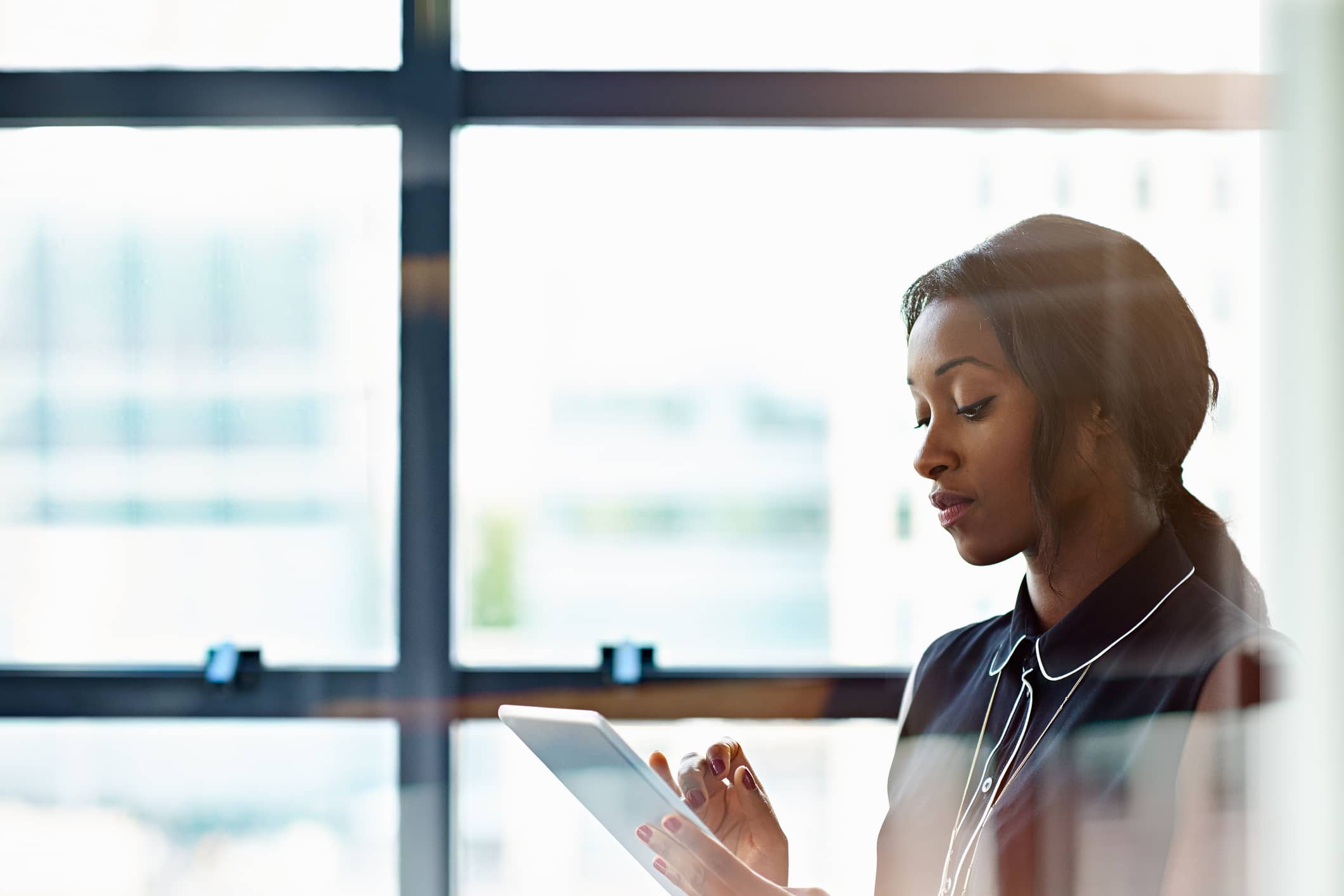 A woman using a tablet. Securing mobile devices is an important part of web security for business